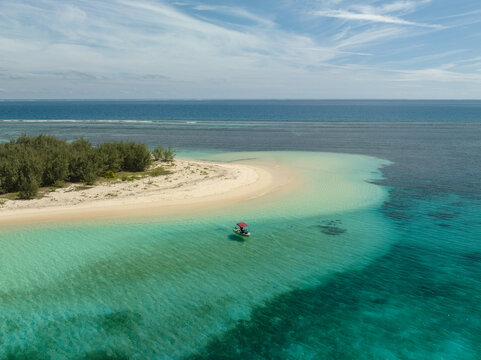 Aerial view of a pristine island with turquoise waters meeting the shore, Noumea, New Caledonia.