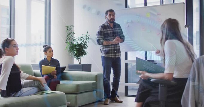 Male presenter gesturing, introducing topic and leading business meeting at board with sticky notes
