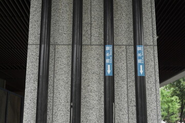 Obraz premium Vertical Rain Water Drainage Pipes on Granite Building Pillar.