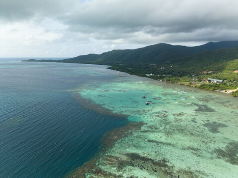 Aerial view of the coast where the deep blue sea meets the vibrant turquoise waters, Karimunjawa, Central Java, Indonesia.