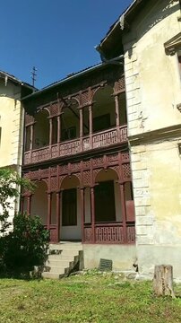 Historic house with intricately carved wooden porch and balcony in Sibiu, Romania. Highlights Transylvanian vernacular craftsmanship, decorative woodwork tradition, and regional architectural identity