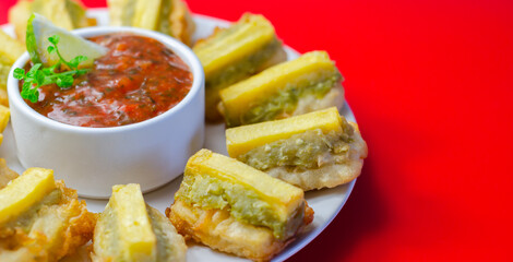 Fried plantain slices surround a spicy dipping sauce © Q77photo