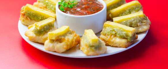Fried plantain slices surround a spicy dipping sauce © Q77photo