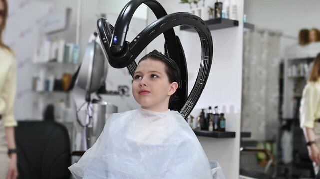 Professional hair treatment with climazone device in beauty salon, modern infrared equipment for coloring, restoration and care, female client during procedure, advanced haircare technology