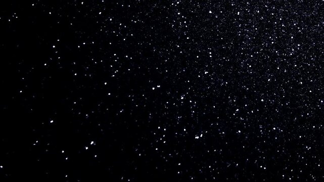 Fine Silver Dust Particles Drifting on Black Background