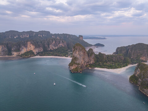 Aerial view of boats sailing through the turquoise waters, surrounded by limestone cliffs and sandy beaches, Krabi, Thailand.