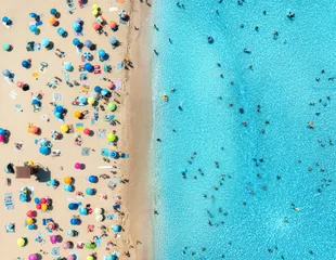 Aerial drone view of colorful umbrellas on sandy beach, swimming people in blue sea on sunny summer day. Top down view. Mallorca, Balearic Islands, Spain. Tropical. Clear turquoise water. Travel © den-belitsky
