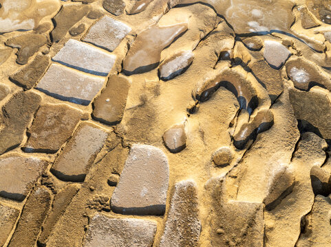 Aerial view of the intricate patterns of sun-baked earth and stone form a mosaic of textures and tones, creating a captivating natural artwork, Malta
