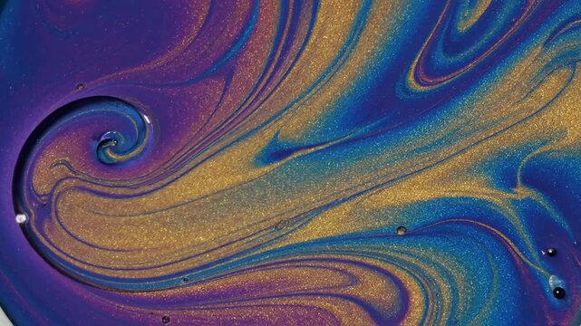 Abstract fluid art shows swirling oil slick patterns or Iridescent gold and blue fluid swirls create an abstract backdrop