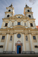 Fototapeta premium Basilica of the Seven Sorrows of the Blessed Virgin Mary with twin towers and ornate facade featuring religious statues and a bright blue entrance door under a clear sky, Sastin-Straze, Slovakia