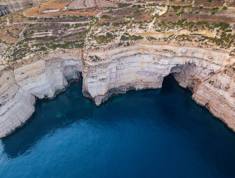 Aerial view of dramatic Sanap Cliffs plunging into the deep blue sea, creating a striking contrast of textures and tones, Munxar, Gozo, Malta.