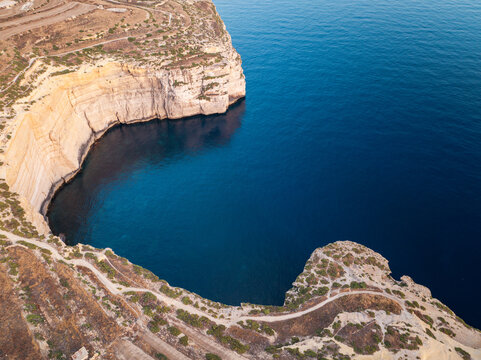 Aerial view of the rugged Sanap Cliffs plunging into the deep blue sea, creating a mesmerizing contrast of earth and water, Munxar, Gozo, Malta.