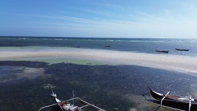 Aerial view of traditional Bangka boats floating on calm tropical sea with clear water creating a peaceful minimal coastal scene around Bantayan Island Philippines Southeast Asia