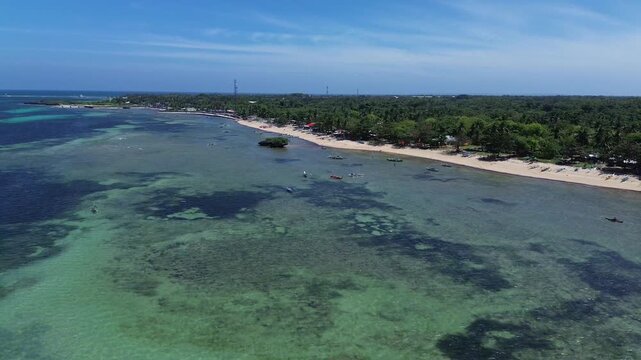 Aerial view of a tropical island coastline with white sand beach clear ocean water and dense green vegetation creating a pristine and untouched landscape on Bantayan Island Philippines Southeast Asia