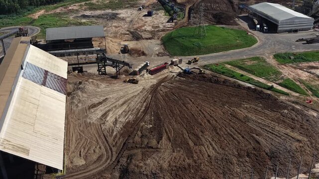 Aerial video footage of a construction site with a large dirt pile and buildings under development