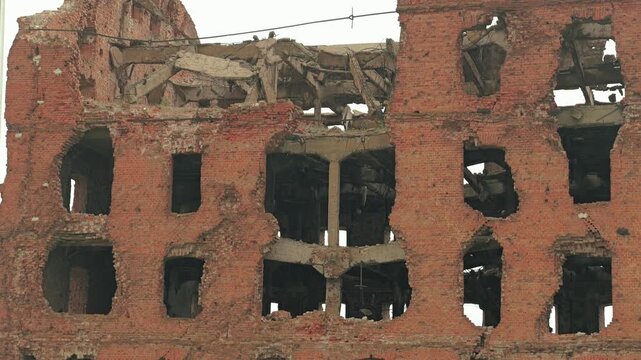Derelict brick building destroyed in battle. Facade shows heavy damage, bullet holes and shell impacts. A somber, historic monument to the aftermath of war. Gerhardt Mill