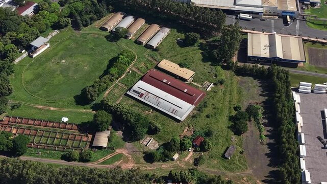 Aerial video footage of a serene farm with lush greenery and modern buildings