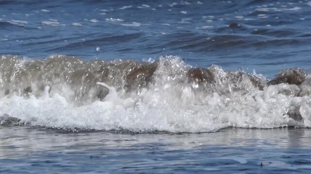 Slow motion of polluted sea waves with dark foam from a spill, runoff of petroleum products from a petrochemical. Environmental disaster. Tuapse , oil spill at sea, oil pollution. War Iran. Hormuz	