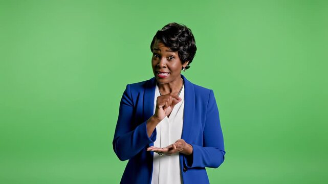 Professional african american woman explaining something against green screen using hand gestures demonstrating a little bit or small amount