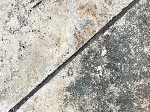 Close up of old weathered cracked concrete or cement screed with weathered grunge texture, and grouts lining pattern. Suitable for flooring and old building. Seamless background texture. 