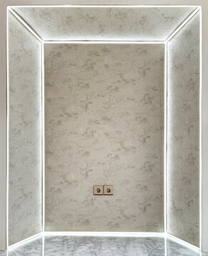 Close up of futuristic aesthetic interior wall panel with white illuminated led frame, and beveled shape inside. Finished with wallpaper and white paint. For photo backdrop, and wall. Seamless texture