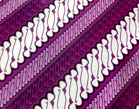 Graphic design of ornamental Batik fabric in random cut shape. Pattern, paisley, and abstract engraved textile design in shades of purple, magenta, and white color. Seamless background texture.