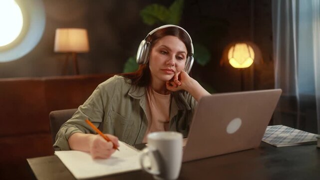 Boring unmotivated young woman student listening online lecture by laptop computer at home workplace Tired girl with uninteresting lesson on remote distance education indoors