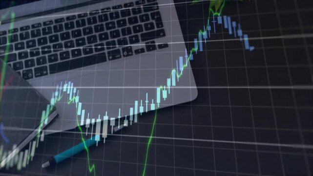 Top-down desk showing laptop chart overlay rising from corner obscuring screen showing market swing