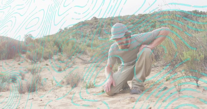 Spotting small pebbles, adult man kneeling and sifting sand, turquoise overlay highlighting geology