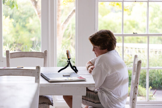 12 year old boy using smart phone on tripod at home