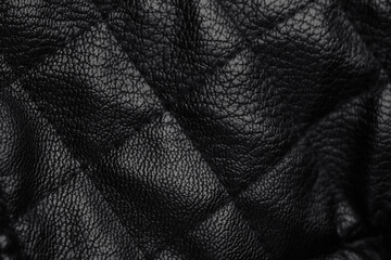Obraz premium Detailed close up of dark black quilted leather material surface featuring classic diamond pattern