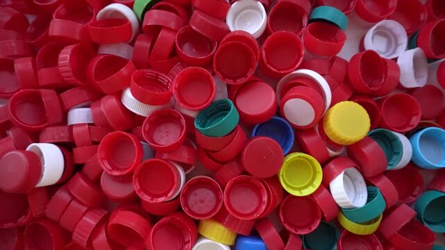 Lots of plastic caps in different colors. Red and multicolored caps on the surface, close-up.