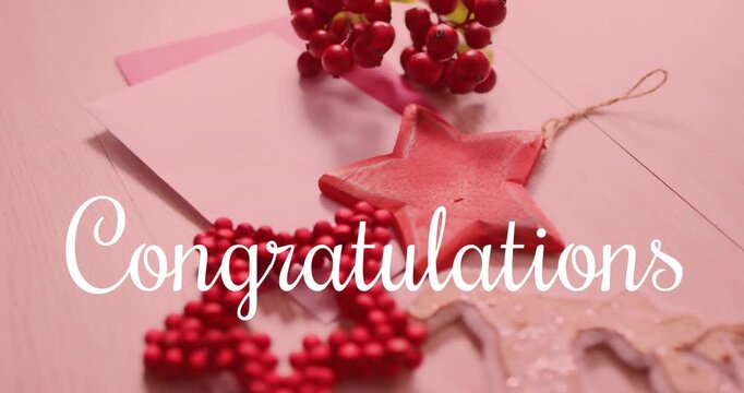Animation of confratulations text over christmas decorations on pink backrgound