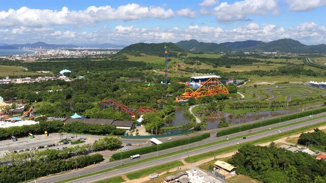 Aerial reveal of Beto Carrero World theme park with roller coasters and surrounding landscape.