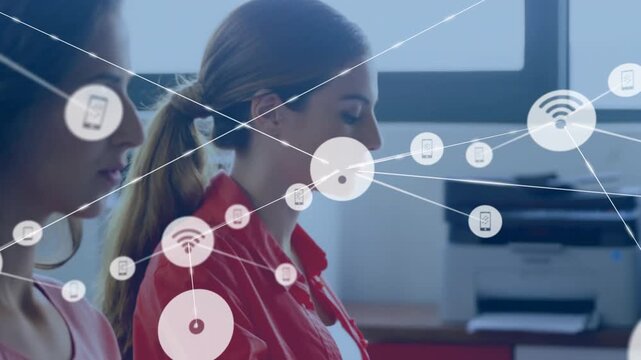 Two women sitting in office, system activating HUD wifi, phone icons overlaying subjects for demo