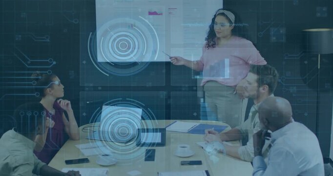 Presenter standing and pointing at display, causing HUD overlay and explaining charts for business