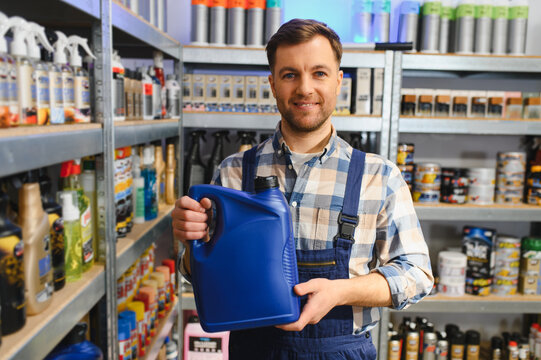 Male store worker holding engine oil in auto parts shop