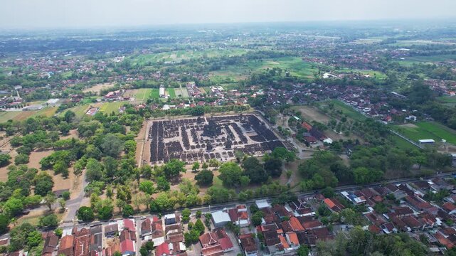 Aerial drone footage of Prambanan hindu temple and it's park from outside, with villages around and forests, in Klaten and Sleman regency, Java island, Indonesia