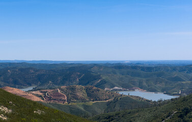 Fototapeta premium Lake with trees and a hill formation on the horizon.
