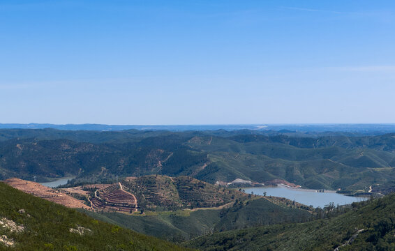 Lake with trees and a hill formation on the horizon.