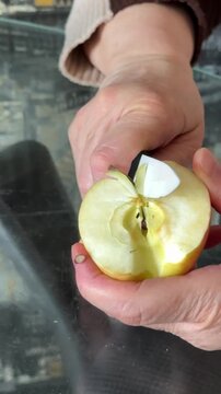 female hands cutting apple in kitchen and woman eat. High quality 4k footage