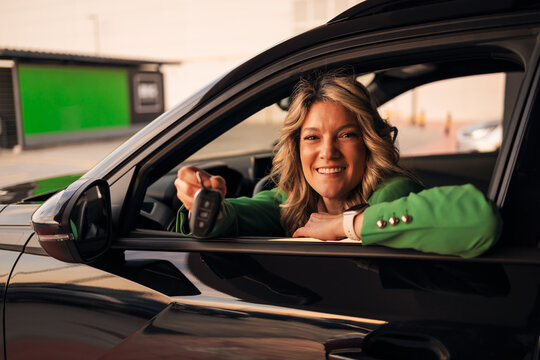 Happy woman holding car keys, buying new vehicle