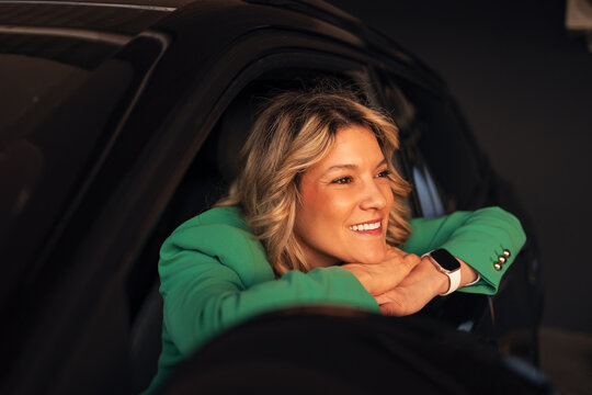 Smiling woman enjoying car ride and urban lifestyle