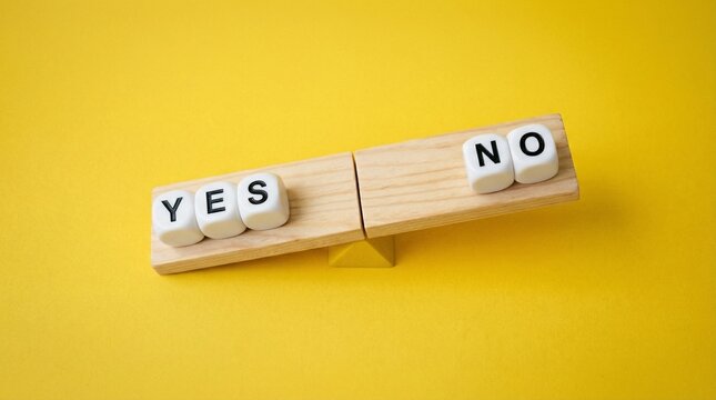 Yes and No Decision: A conceptual shot with wooden blocks spelling Yes and No arranged on a seesaw against a vibrant yellow background, symbolizing the pivotal choices we encounter.