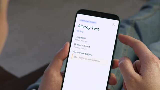 Close up hands holding smartphone viewing allergy test results on medical app. Patient checking electronic health records for pollen allergy diagnosis. Modern telemedicine, e-health and digital