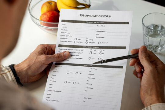Filling out job application form at home with pen. Employment, hiring and career concept