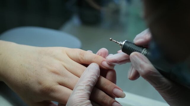 Professional manicure with transparent white latex gloves. Nail technician gently shapes and cares for nails, creating a clean and polished look.