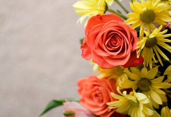 Naklejka premium Vibrant close up of orange roses and yellow daisies bouquet with soft bokeh background for romantic greeting cards and floral advertising.