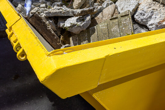 Close up of a bright yellow construction dumpster The Concept of Waste Management