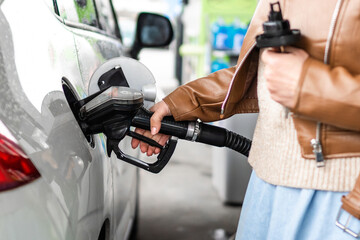 Woman Pumping Fuel Into A Car At A Petrol Station © tan4ikk